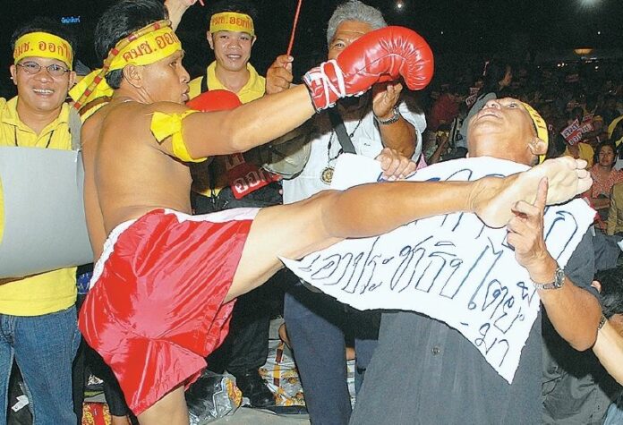 A man dressed as a Muay Thai fighter 'knocks out' a man representing the previous junta in a campaign opposing its 2007 draft constitution in a June 2007 file photo.