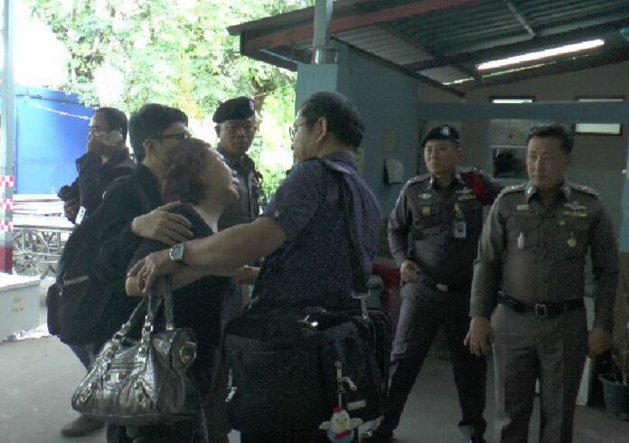 Police escort the crying mother of murder victim Lee Jae-hun on Dec. 16 outside a Korat hospital where her son’s body was taken for examination.