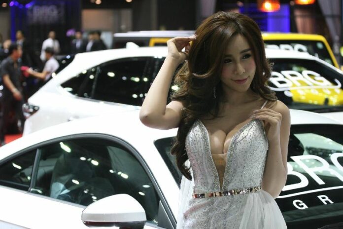 A promotional model, aka ‘pretty,’ poses Dec. 1, 2015 for a photograph at Bangkok’s Motor Show.