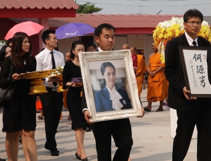 A relative of car crash victim Thantapat Horsaengchai carries her portrait at her cremation ceremony on Saturday in Pathum Thani province.