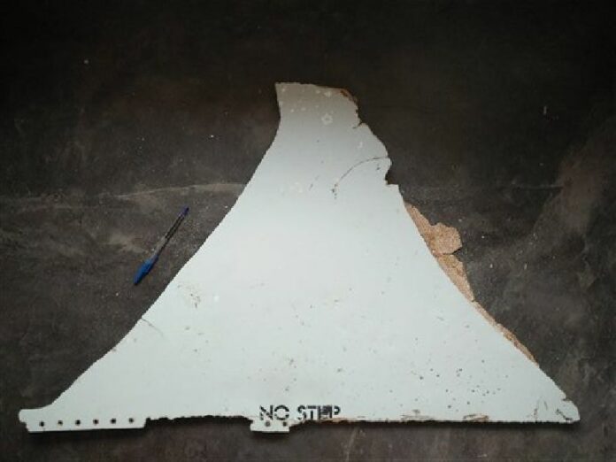 In this Feb. 28, 2016 image provided by Blaine Gibson and the Australian Transport Safety Bureau (ATSB), a piece of aircraft debris with the words "NO STEP" is photographed after it was found washed up on a beach in Mozambique. Photo: Blaine Gibson / Associated Press