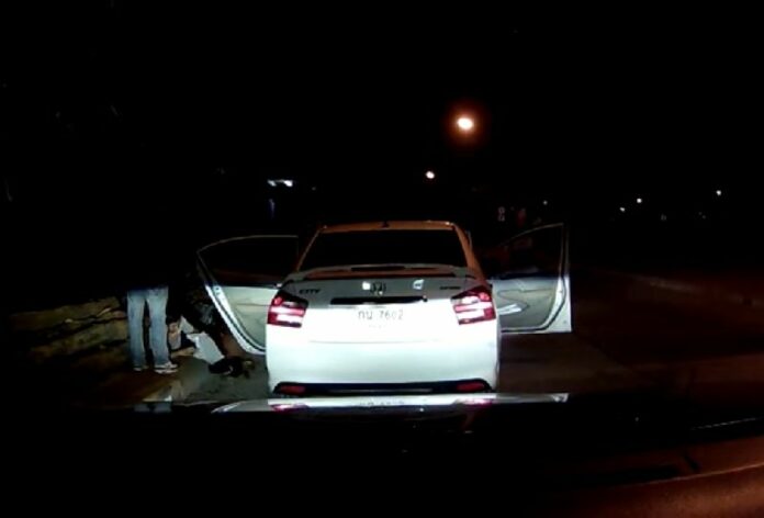 Police investigators confront a group of students outside their vehicle March 18 in Phitsanulok province in a still image taken from a dashcam video of the incident.
