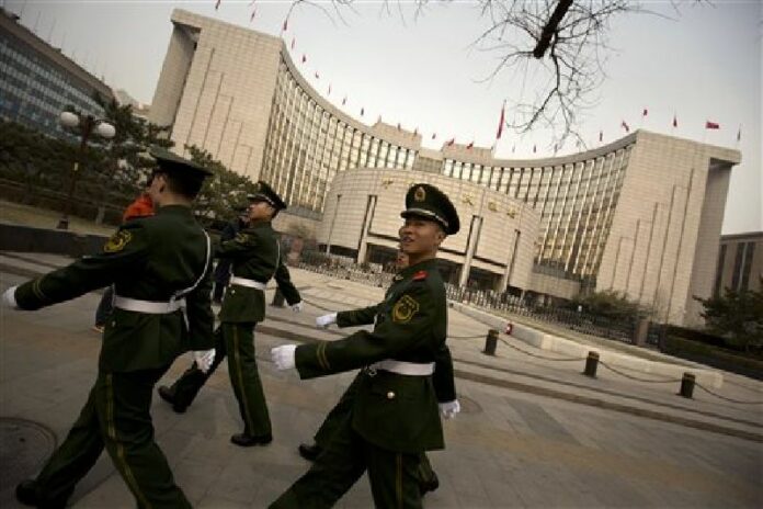 Chinese paramilitary police march past China's central bank, the People's Bank of China, in Beijing, Saturday, March 12, 2016 Photo: Mark Schiefelbein / Associated Press