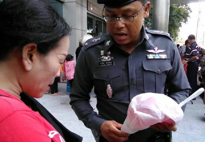 A police officer seizes a plastic red bowl from a supporter of former Prime Minister Yingluck Shinawatra on Friday in Bangkok. Photo: Matichon