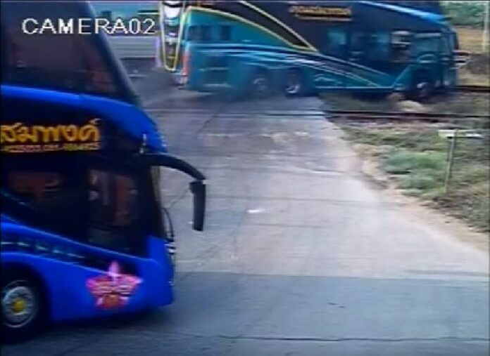 A bus is knocked off the tracks by a train Sunday at an uncontrolled intersection west of Bangkok in a still image from security camera footage.