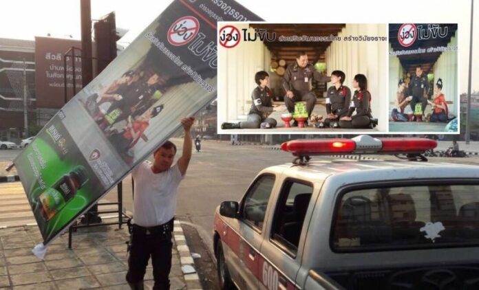 A controversial poster being taken away by a police officer on Sunday in Chiang Mai city