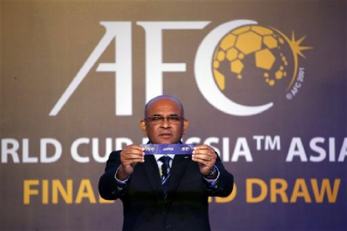 Asian Football Confederation (AFC) General Secretary Windsor John holds the country name card of Japan in the draw for 2018 FIFA World Cup Asian qualifiers final round in Kuala Lumpur, Malaysia on Tuesday, April 12, 2016. Photo: Vincent Thian / Associated Press