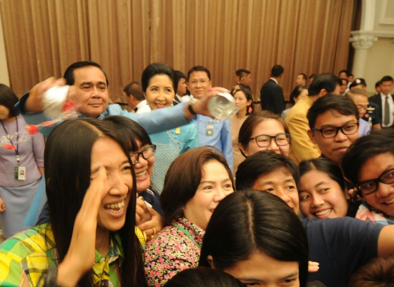 Gen. Prayuth Chan-ocha splashes water on the media to mark Thai New Year at Government House