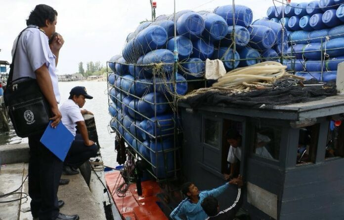 Officials investigate workers at Saphan Pla pier in Ranong province, 27 April 2015.<br />