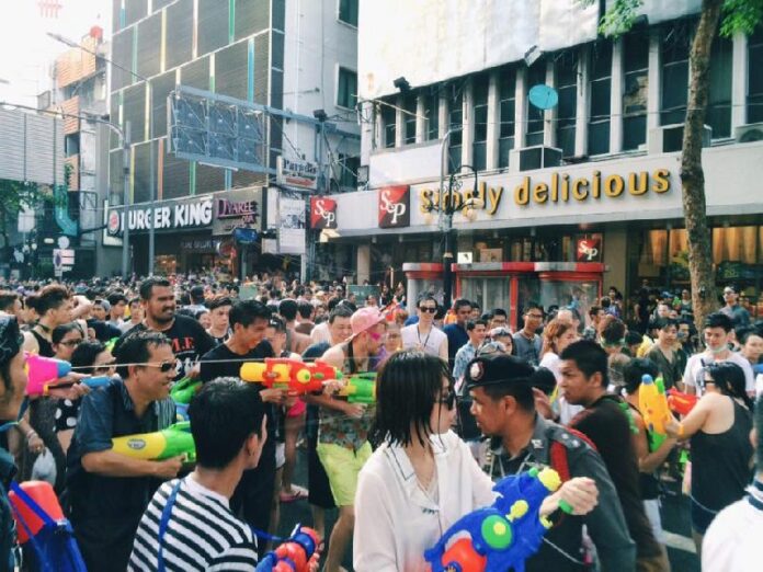 A crowd firing water at a police officer on Wednesday at Silom Road