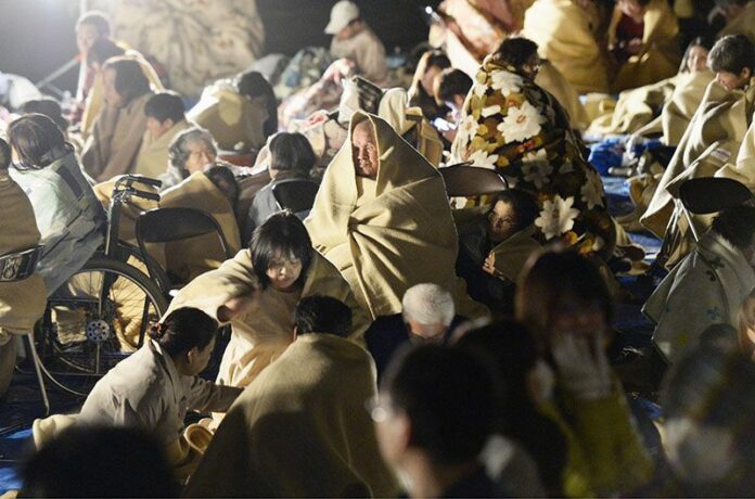 Residents wrap themselves in blankets as they take shelter outside the town hall of Mashiki, near Kumamoto city in southern Japan, after the earthquake early Friday morning. Photo: Ryosuke Uematsu / Kyodo News / Associated Press