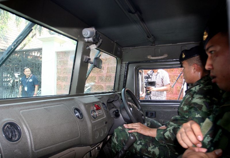 Soldiers wait outside the home of former Pheu Thai MP Watana Muangsuk on Thursday in Bangkok’s Prawet district.