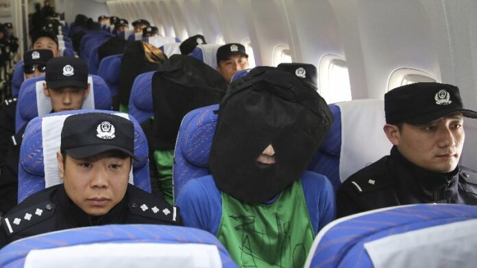 Chinese and Taiwanese suspects involved in wire fraud sit in a plane as they arrive at the Beijing Capital International Airport in Beijing, China, in a photo released by Xinhua News Agency. Photo: Yin Gang / Xinhua News Agency / Associated Press
