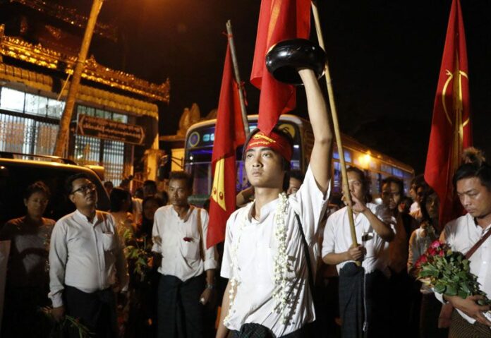 Phyo Dana, a student protester who recently released from Thayarwaddy Prison with President's pardon, holds an alms bowl upside-down in a symbol of protest during a gathering near Shwedagon pagoda on April 8 in Yangon, Myanmar. Photo: Thein Zaw / Associated Press<br />