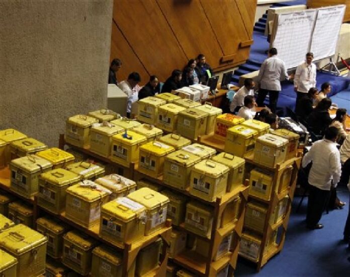 In this Wednesday, May 26, 2010, file photo security personnel and staff members of the Lower House keep a close eye on ballot boxes containing certificates of canvass, during the second day of deliberations of the National Board of Canvassers at the House of Representatives in Quezon City north of Manila, Philippines. Photo: Pat Roque / Associated Press