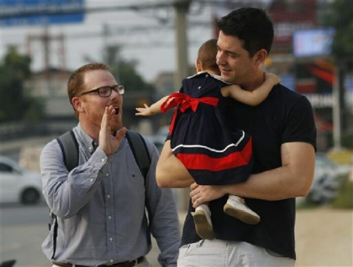 American Gordon Lake, left, and Manuel Santos, right, with their baby Carmen on March 23 at the Central Juvenile and Family Court in Bangkok. Photo: Sakchai Lalit / Associated Press