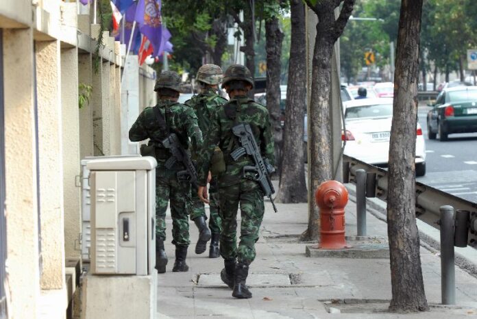 In this March 17, 2015, file photo, soldiers patrol the Criminal Court in Bangkok.
