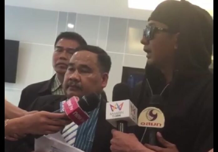Attorney Songkran Atchariyasap, second from left, and ‘Fuck Ghost’ administrator ‘Kiattisak,’ at right, speak to reporters Wednesday at the Crime Suppression Division in Bangkok in a scene from Sonkgran’s Facebook Live stream.