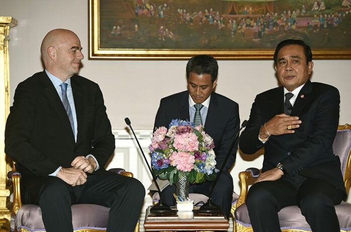 FIFA President Gianni Infantino, at left, listens to junta chairman and Prime Minister Prayuth Chan-ocha, at Government House on Thursday in Bangkok. Photo: Lillian Suwanrumpha / Associated Press