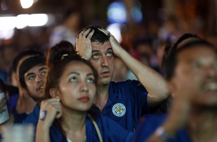 Leicester City fans react as they watch the English Premier League soccer match between Leicester City and Manchester United on TV on Sunday in Bangkok. Photo: Sakchai Lalit / Associated Press