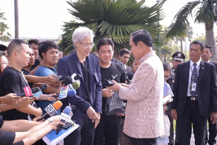 President of Thai Journalists Association Wanchai Wongmeechai offers a black campaign t-shirt to Prime Minister Prayuth Chan-ocha Tuesday on the occasion of World Press Freedom Day at Government House.