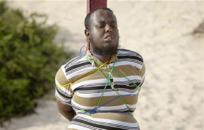 Hassan Hanafi Haji, a former journalist accused of belonging to al-Shabab and involvement in the killings of five Somali journalists, is tied to a wooden post as he is prepared to be executed by firing squad, at a police academy in the capital Mogadishu, Somalia Monday, April 11, 2016. Photo: Farah Abdi Warsameh / Associated Press