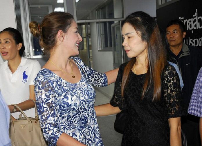 Actress Anna Reese puts her arms around Chanthana Wongbundit, the wife of Police Lt. Naphadol Wongbundit, at a Bangkok police station on Aug. 22 after agreeing to pay an undisclosed amount of restitution to the family.
