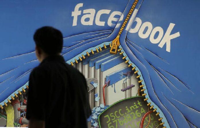 In this June 11, 2014, file photo, a man walks past a mural in an office on the Facebook campus in Menlo Park, Calif. Photo: Jeff Chiu / Associated Press