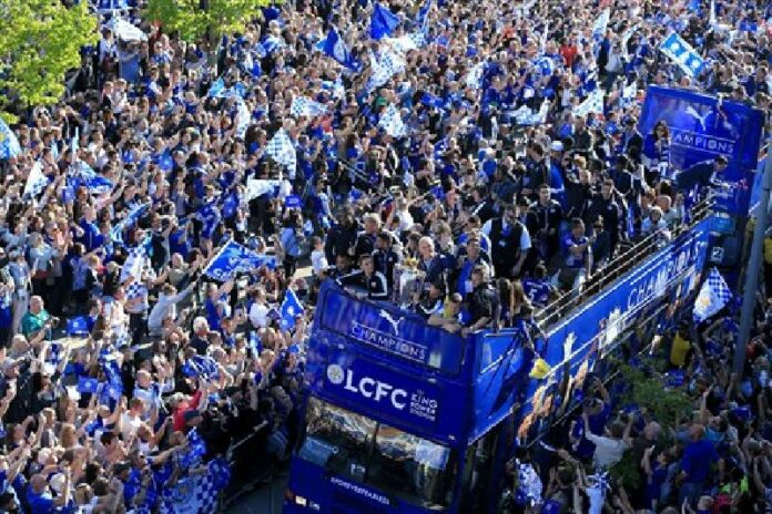 Leicester City players and staff celebrate with the trophy after winning the English Premier League during an open top bus parade through Leicester city centre, England, Monday May 16, 2016. Photo: Tim Goode / Associated Press