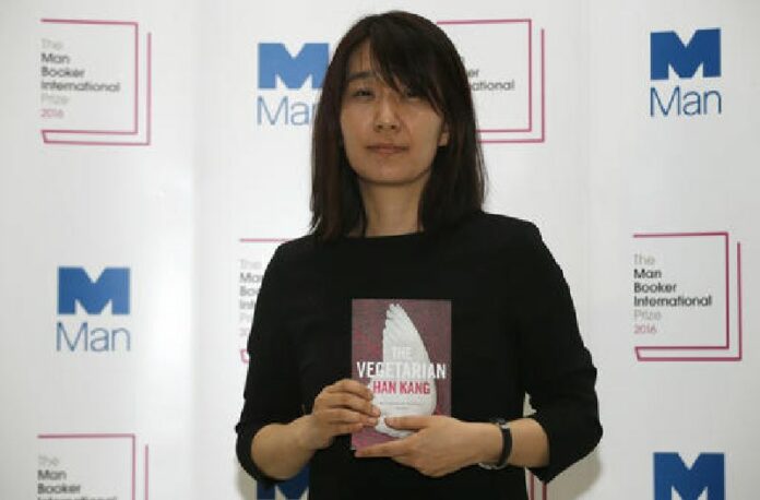 Winner of the 2016 Man Booker International prize for fiction Han Kang poses for the media with her book 'The Vegetarian' following the award ceremony in London, Monday, May, 16, 2016. Photo: Alastair Grant / Associated Press