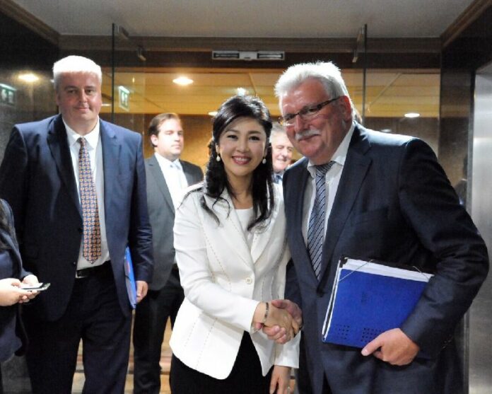Werner Langen, chairman of a delegation of E.U. parliamentarians to Southeast Asia, shakes hands with former Prime Minister Yingluck Shinawatra on Tuesday at Pheu Thai Party headquarters in Bangkok.