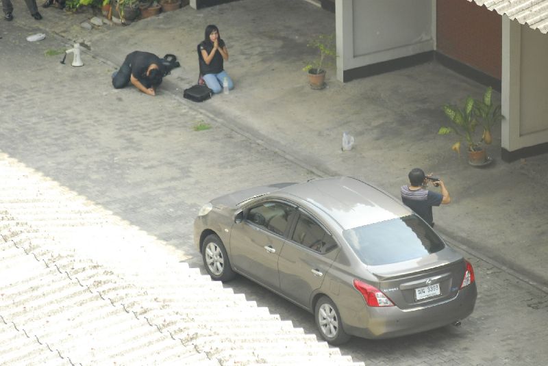 Wanchai Danaitamonut points a gun to his head during police investigation.  