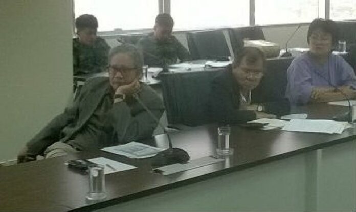 Two uniformed soldiers sit at the back of a room Friday afternoon at the Law Reform Commission in Nonthaburi where civic groups were discussing the draft charter.